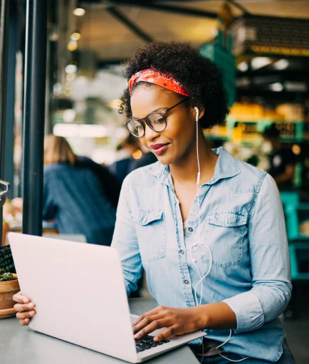 Una mujer trabajando en una computadora portátil en una cafetería